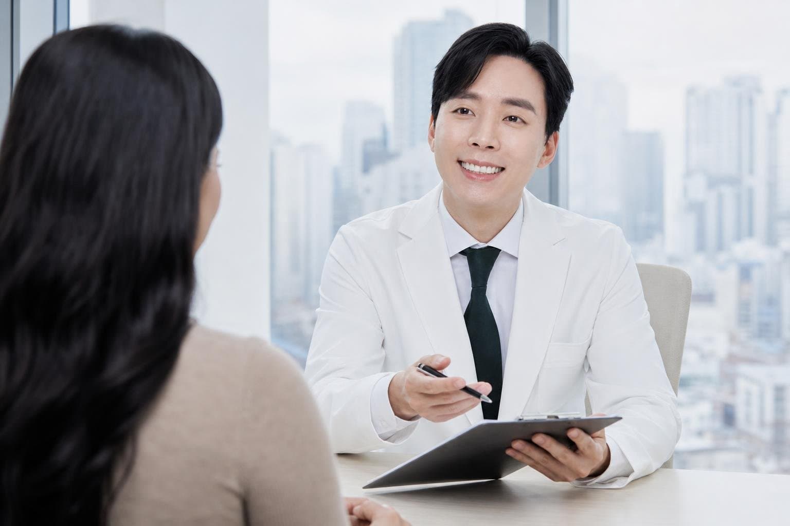 Dr. Min Jeong with a patient at REDI Dermatology in Seoul, discussing flying after skin treatment